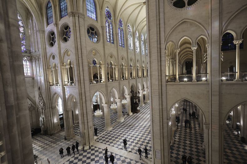 Gente camina por la catedral de Notre-Dame de París mientras el presidente francés Emmanuel Macron visita los interiores restaurados del monumento, el viernes 29 de noviembre de 2024 en París. (Christophe Petit Tesson, Pool vía AP)