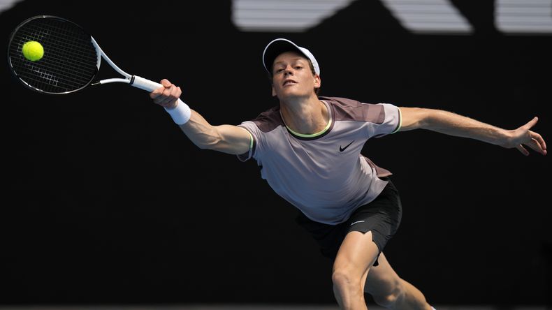 El italiano Jannik Sinner hace una devolución al holandés Botic van de Zandschulp en la primera ronda del Abierto de Australia, el domingo 14 de enero de 2024 (AP Foto/Andy Wong)
