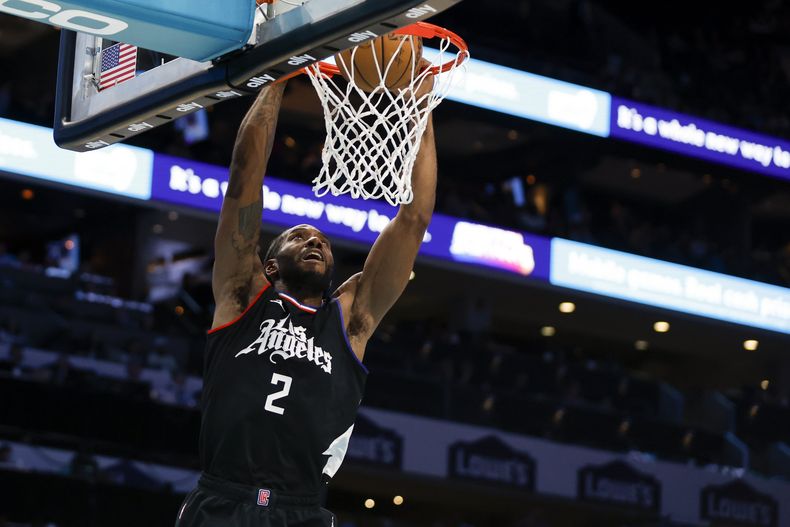 En foto del 31 de marzo de 2024, Kawhi Leonard, alero de los Clippers de Los Ángeles, realiza una clavada en el partido ante los Hornets de Charlotte. El martes 30 de abril del 2024, Leonard se perderá el juego 5 de la serie de primera ronda ante los Mavericks de Dallas. (AP Foto/Nell Redmond)