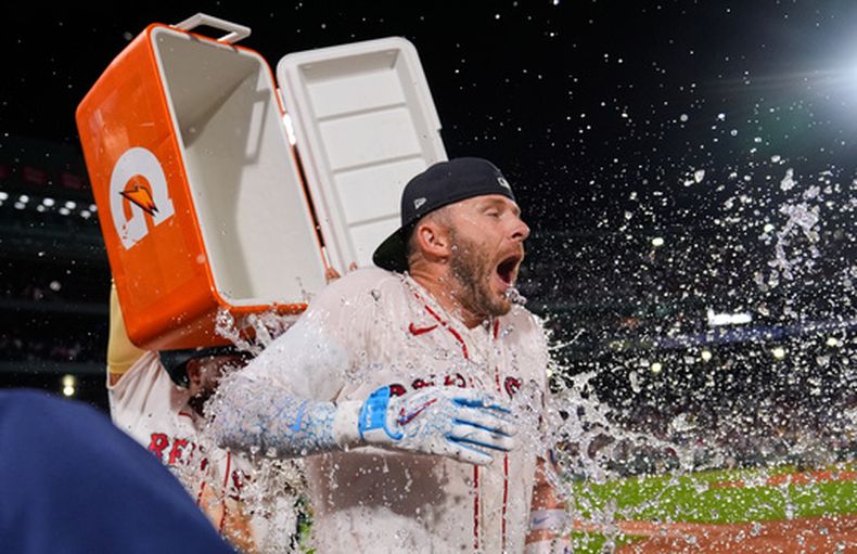 Trevor Story, de los Medias Rojas de Boston, recibe un baño con una hielera después de producir la carrera de la victoria en el juego de béisbol de Grandes Ligas contra los Marineros de Seattle en la parte baja de la décima entrada, el lunes 31 de agosto de 2026, en Boston. (AP Foto/Charles Krupa)