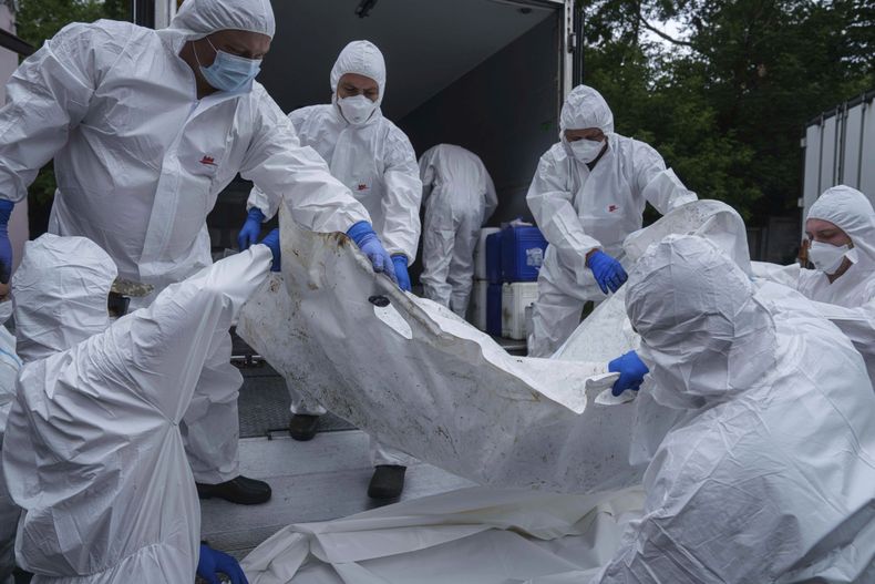 Elementos del Ejército ucraniano trasladan el cadáver de un compañero repatriado de Rusia, en la morgue de Kiev, Ucrania, el jueves 26 de junio de 2025. (AP Foto/Evgeniy Maloletka)