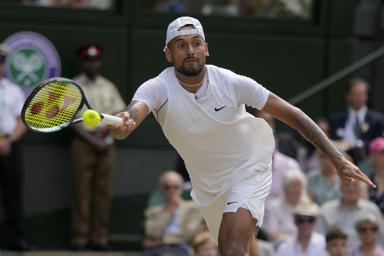 ARCHIVO - El australiano Nick Kyrgios hace una devolución al serbio Novak Djokovic en la final de Wimbledon, el 10 de julio de 2022 (AP Foto/Alastair Grant, archivo)