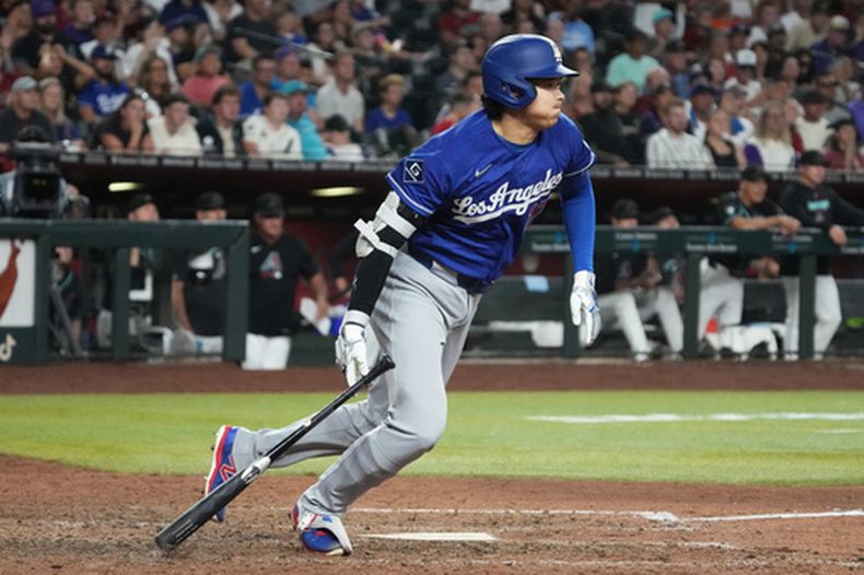 Shohei Ohtani, de los Dodgers de Los Ángeles, batea un sencillo productor en el décimo inning del juego del sábado 8 de agosto de 2026 ante los Diamondbacks de Arizona (AP Foto/Rick Scuteri)