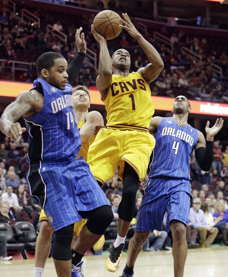 Jarrett Jack (1), de los Cavaliers de Cleveland, tira entre Jameer Nelson (14) y Arron Afflalo (4), del Magic de Orlando, en el tiempo extra del juego del jueves 2 de enero de 2014, en Cleveland. (Foto AP/Tony Dejak)