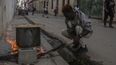 Un hombre cocina sopa sobre una fogata en una acera durante un apagón en La Habana, Cuba, el miércoles 4 de diciembre de 2024. (AP Foto/Ramón Espinosa)