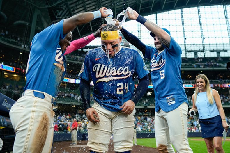 Luis Lara, izquierda, y Garrett Mitchell (5), de los Cerveceros de Milwaukee, bañan a William Contreras (24) después de la victoria de su equipo frente a los Bravos de Atlanta en juego de béisbol de Grandes Ligas, el viernes 21 de agosto de 2026, en Milwaukee. (AP Foto/Kayla Wolf)