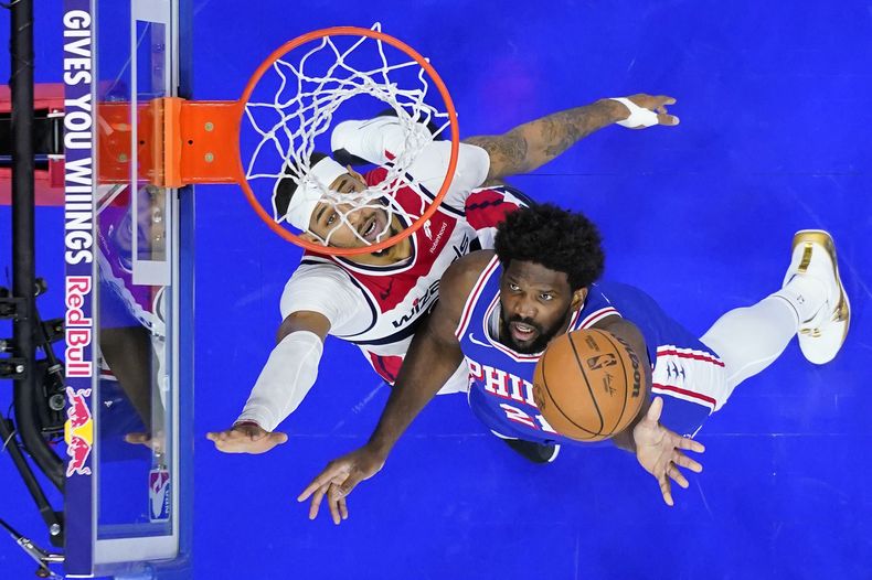 Joel Embiid, derecha, de los 76ers de Filadelfia, se alza para tomar un tiro en contra de Daniel Gafford, de los Wizards de Washington, durante la segunda mitad del juego de baloncesto de la NBA, el lunes 6 de noviembre de 2023, en Filadelfia. (AP Foto/Matt Slocum)