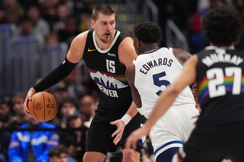 El serbio Nikola Jokic, de los Nuggets de Denver, encara a Anthony Edwards, de los Timberwolves de Minnesota, en la prórroga del partido del jueves 25 de diciembre de 2025 (AP Foto/David Zalubowski)