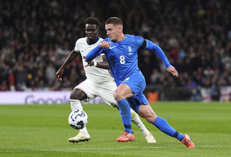 Bukayo Saka (izquierda), de la selección inglesa, disputa un balón con el griego Christos Tzolis durante un partido de la Liga de Naciones de la UEFA, el jueves 10 de octubre de 2024 (Bradley Collyer/PA via AP)
