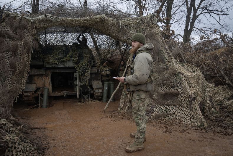 Un oficial de la 12da Brigada de Fuerzas Especiales Azov de la Guardia Nacional se prepara para disparar un arma M109 Paladin hacia posiciones rusas, en el frente de batalla cerca de Kreminna, Ucrania, el domingo 28 de enero de 2024. (AP Foto/Efrem Lukatsky)