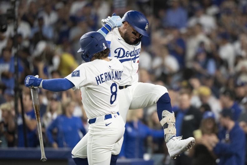 El venezolano Miguel Rojas festeja con el boricua Kiké Hernández, después de batear un jonrón por los Dodgers de Los Ángeles en el duelo ante los Gigantes de San Francisco, el viernes 19 de septiembre de 2025 (AP Foto/Kyusung Gong)