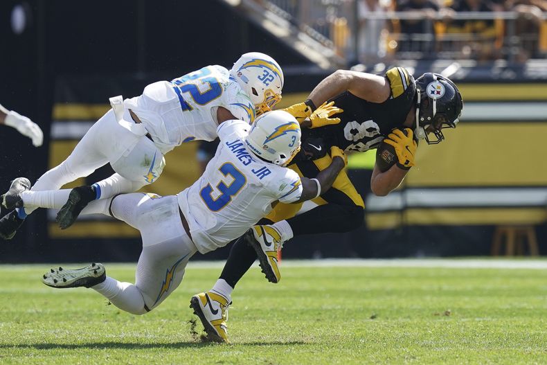 El ala cerrada de los Steelers de Pittsburgh, Pat Freiermuth, a la derecha, es tacleado por los safeties de los Chargers de Los Angeles , Alohi Gilman (32) y Derwin James Jr., durante la segunda mitad de un partido de fútbol americano de la NFL, el domingo 22 de septiembre de 2024, en Pittsburgh. (AP Foto/Matt Freed)