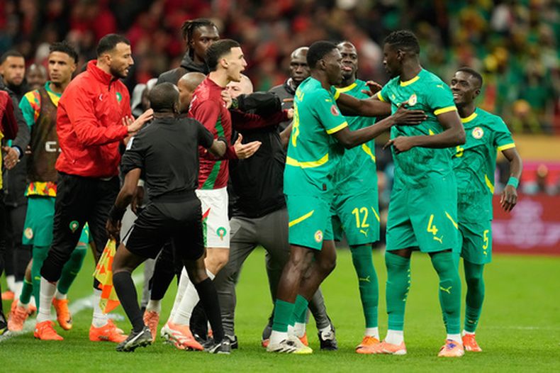 Los jugadores de Marruecos y Senegal se pelean tras pitarse un penal en la final de la Copa Africana de Naciones, el domingo 18 de enero de 2026, en Rabat. (AP Foto/Mosaab Elshamy)