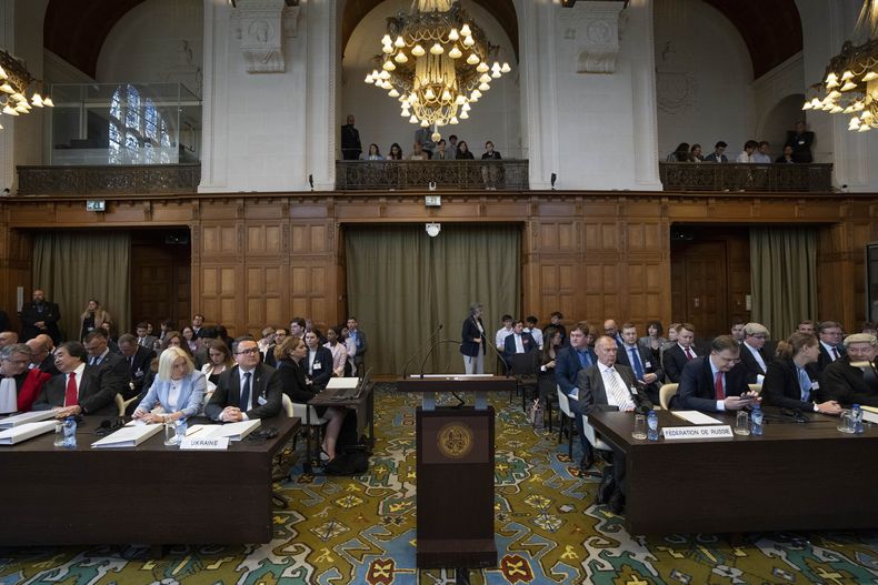 La delegación de Ucrania (izquierda) espera la llegada de los jueces a la Corte Internacional de Justicia, en La Haya, Holanda, el 6 de junio de 2023. (AP Foto/Peter Dejong)