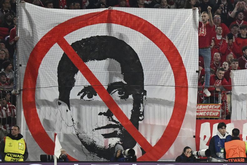 Hinchas de Múnich sostienen una pancarta contra Nasser Al-Khelaifi, presidente del Paris Saint-Germain, durante el partido de fútbol entre el FC Bayern y el Paris Saint Germain, en el Allianz Arena de Múnich, Alemania, el martes 26 de noviembre de 2024. (Tom Weller/dpa vía AP)