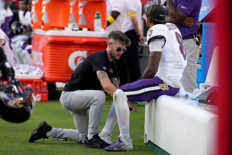 El quarterback de los Ravens de Baltimore, Lamar Jackson, se sienta en el banquillo mientras recibe atención en la pierna durante la segunda mitad de un juego de fútbol americano de la NFL contra los Chiefs de Kansas City, el domingo 28 de septiembre de 2025, en Kansas City, Misuri. (AP Photo/Charlie Riedel)