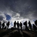Solicitantes de asilo esperan a ser procesados el viernes 2 de febrero de 2024 en un campamento improvisado cerca de Jacumba Hot Springs, California, luego de cruzar la frontera sur de Estados Unidos. (AP Foto/Gregory Bull)