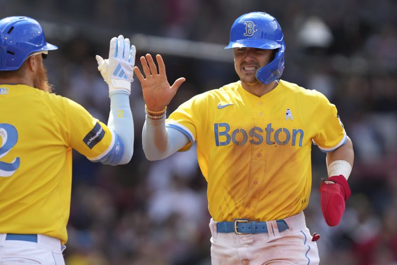 Enrique Hernández (derecha) de los Medias Rojas de Boston es recibido por Justin Turner tras anotar una carrera ante los Yanquis de Nueva York, el domingo 18 de julio de 2023, en Boston. (AP Foto/Steven Senne)