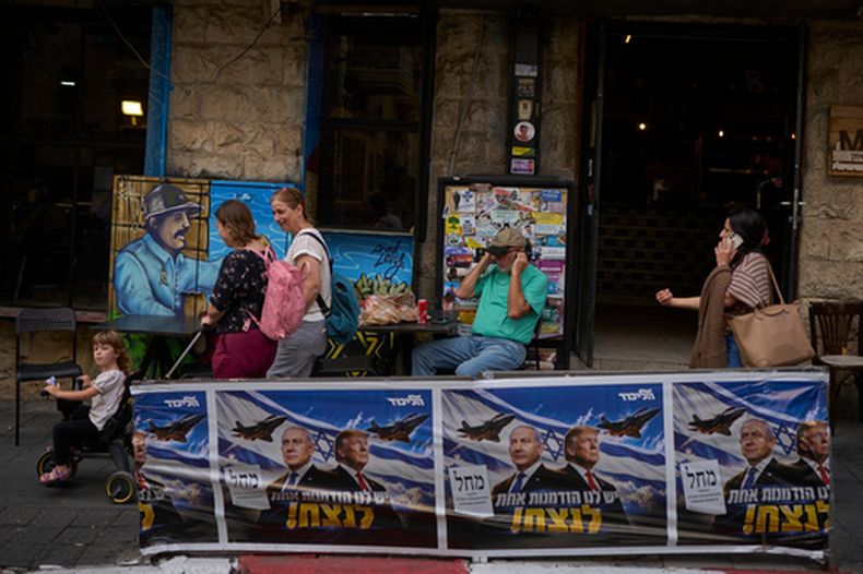 Gente camina junto a carteles de campaña del partido Likud que muestran al primer ministro de Israel, Benjamin Netanyahu, y el presidente de Estados Unidos, Donald Trump, con el mensaje en hebreo Tenemos una oportunidad para ganar, en Jerusalén, el miércoles 28 de 2026, al día siguiente de las elecciones en Israel. (AP Foto/Ohad Zwigenberg)