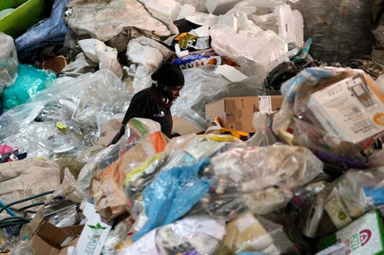 Un trabajador clasifica materiales reciclables en un montón de basura en la empresa de gestión de residuos Whole Earth Recycling, el martes 28 de julio de 2026, en Johannesburgo, Sudáfrica. (AP Foto/Themba Hadebe)