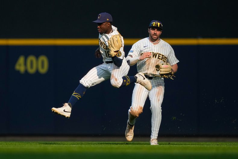 El jardinero central de los Cerveceros de Milwaukee, Luis Lara (18), realiza una atrapada en carrera frente al jardinero central Garrett Mitchell (5) a un elevado conectado por Javier Sanoja, de los Marlins de Miami, durante la octava entrada de un partido de béisbol el sábado 18 de julio de 2026, en Milwaukee. (Foto AP/Kayla Wolf)