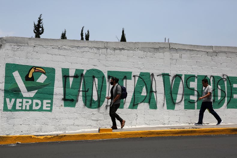 Archivo - Peatones caminan cerca de un mural con una consigna de vota verde para promover al Partido Verde, en Ciudad de México, el 29 de mayo de 2021. En alianza con el partido gobernante Morena, el Partido Verde se convirtió en el segundo bloque más votado del Congreso, tras las elecciones del 2 de junio de 2024. (AP Foto/Ginnette Riquelme, Archivo)