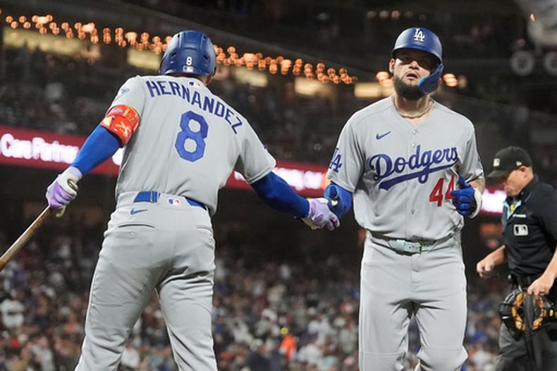 Andy Pagés, derecha, de los Dodgers de Los Ángeles, es felicitado por Enrique Hernández (8) despúes de batear un jonrón frente a los Gigantes de San Francisco durante la segunda entrada del juego de béisbol de Grandes Ligas del viernes 25 de septiembre de 2026, en San Francisco. (AP Foto/Jeff Chiu)
