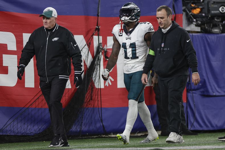 El wide receiver de los Eagles de Philadelphia A.J. Brown (11) camina afuera del terreno de juego con una lesión durante el primer cuarto del juego de la NFL ante los Giants de Nueva York, el domingo 7 de enero de 2024, en East Rutherford, Nueva Jersey. (AP Foto/Adam Hunger)