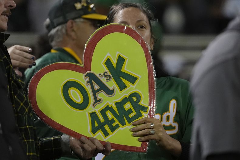 Una seguidora de los Atléticos de Oakland muestra un letrero tras el encuentro del miércoles 25 de septiembre de 2024, ante los Rangers de Texas (AP Foto/Jeff Chiu)