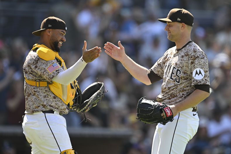 El abridor de San Diego, Michael King (34), derecha, es felicitado por Elias Diaz (17) después de que los Padres derrotaran 6-0 a los Rockies de Colorado en el juego de béisbol de Grandes Ligas, el domingo 13 de abril de 2025, en San Diego, California. (AP Foto/Denis Poroy)
