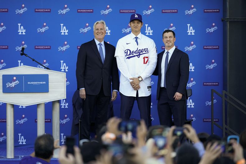 Shohei Ohtani, centro, de los Dodgers de Los Ángeles, posa a un lado del dueño y presidente del equipo, Mark Walter, izquierda, y el presidente de operaciones de béisbol, Andrew Friedman, durante una conferencia de prensa de presentación en el Dodger Stadium, el jueves 14 de diciembre de 2023, en Los Ángeles. (AP Foto/Ashley Landis)