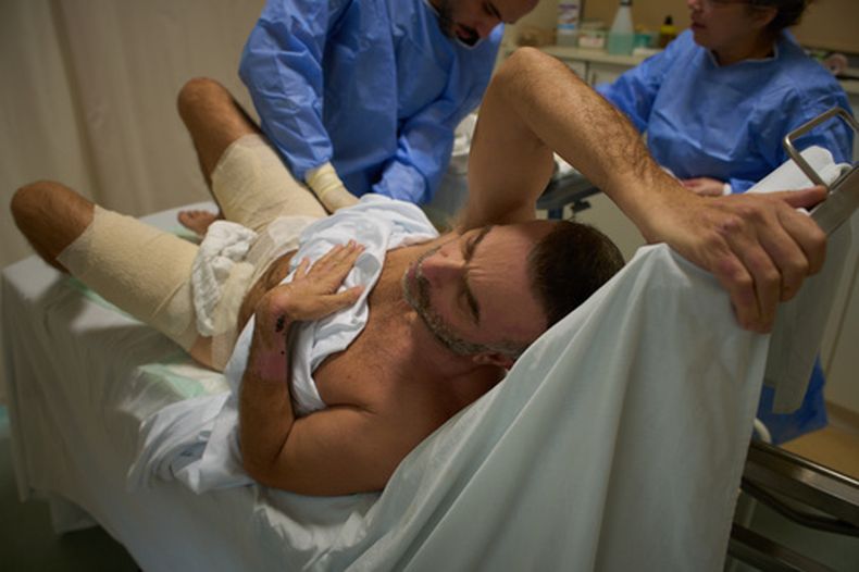 Mohammad Qubaisi, de 53 años, que sufrió quemaduras en un ataque aéreo israelí en el sur de Líbano, durante una cirugía del doctor Mohammed Ziara, a la izquierda, y su equipo, en el hospital gubernamental de Sidón en Sidón, Líbano, el jueves 2 de abril de 2026. (AP Foto/Emilio Morenatti)