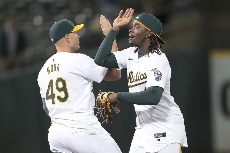 Ryan Noda (49) y Lawrence Butler, de los Atléticos de Oakland, celebran después de que los Atléticos derrotaron a los Piratas de Pittsburgh en un juego de béisbol en Oakland, California, el lunes 29 de abril de 2024. (AP Foto/Jeff Chiu)