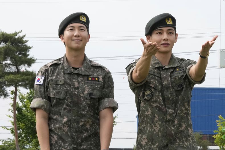 Los miembros de la banda de K-pop BTS, RM, a la izquierda, y V reaccionan después de ser dados de baja del servicio militar obligatorio en Chuncheon, Corea del Sur, el martes 10 de junio de 2025. (Foto AP/Ahn Young-joon)