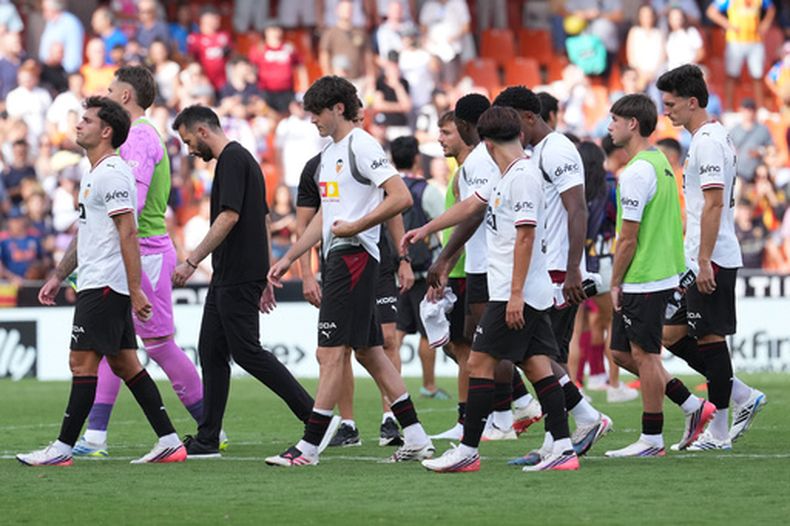 El técnico de Valencia Carlos Corberán, tercero desde la izquierda, y los jugadores del equipo salen del campo después de la derrota por goleada en casa ante Barcelona, en La Liga española, el domingo 6 de septiembre de 2026, en Valencia, España. (AP Foto/Alberto Saiz)