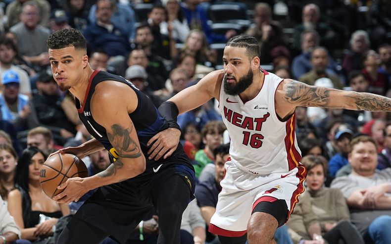 Michael Porter Jr., alero de los Nuggets de Denver, busca pasar el balón frente a Caleb Martin, del Heat de Miami, en el encuentro del jueves 29 de febrero de 2024 (AP Foto/David Zalubowski)
