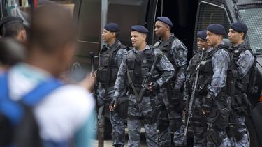 americateve | Polic&iacute;as vigilan la favela Rocinha, la m&aacute;s grande de R&iacute;o de Janeiro, Brasil, el lunes 17 de febrero de 2014. Las autoridades ingresaron al vecindario despu&eacute;s de un fin de semana de tiroteos. (Foto AP/Silvia Izquierdo)