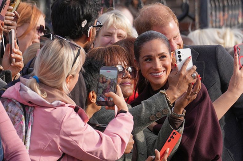 El príncipe Enrique de Gran Bretaña y Meghan, duques de Sussex, posan para fotografías con miembros del público a su llegada para una visita a The Community Recording Studio en Nottingham, Inglaterra, el jueves 15 de octubre de 2026. (Foto AP/Maja Smiejkowska)