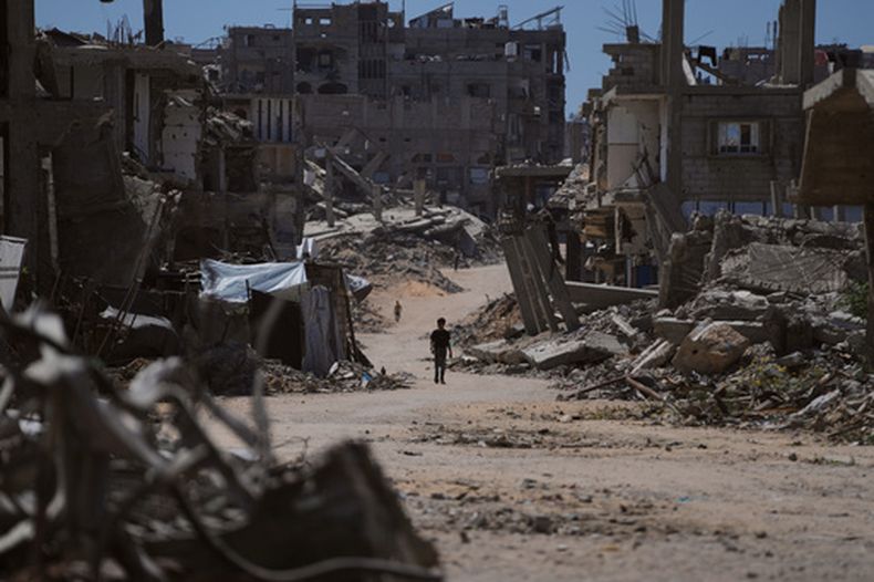 Un niño palestino camina por una calle rodeado de edificio destruidos en ataques militares israelíes durante la guerra entre Israel y Hamás, en Jan Yunis, Gaza, el 1 de julio de 2026. (AP Foto/Abdel Kareem Hana)