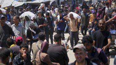 Palestinos cargan bolsas que contienen alimentos y paquetes de ayuda humanitaria entregadas por la Fundación Humanitaria de Gaza, una organización respaldada por Estados Unidos, en Rafah, en el sur de la Franja de Gaza, el domingo 15 de junio de 2025. (AP Foto/Abdel Kareem Hana)