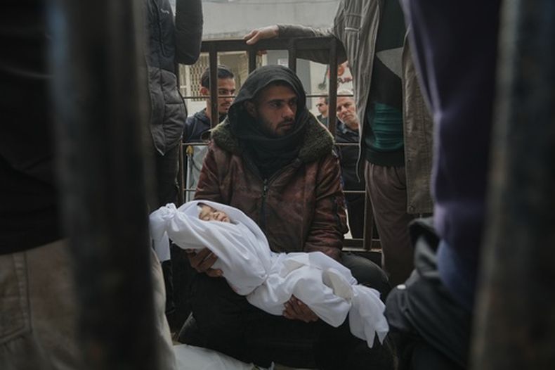 Un familia sostiene el cadáver de una niña de pocos meses, Mira al-Khabbaz, fallecida en un ataque del ejército israelí, antes de su entierro, en el hospital Shifa, en la Ciudad de Gaza, el 4 de febrero de 2026. (AP Foto/Jehad Alshrafi)