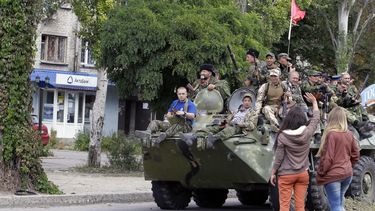americateve | Residentes saludan a rebeldes pro rusos que viajan en un veh&iacute;culo blindado durante un desfile en Lugansk, este de Ucrania, el domingo 14 de septiembre de 2014. (Foto AP/Darko Vojinovic)