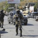 Elementos de la Unidad de Seguridad General del Palacio Nacional de Haití establece un perímetro para retomar el control de una de las tres delegaciones de policía que fueron tomadas por pandillas, en el centro de Puerto Príncipe, Haití, el sábado 9 de marzo de 2024. (AP Foto/Odelyn Joseph)