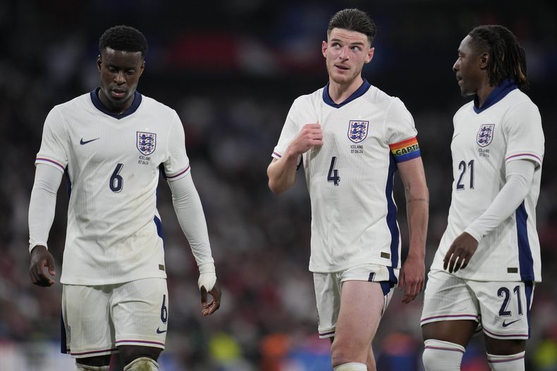 Los jugadores de Inglarerra, Marc Guehl, Declan Rice y Eberechi Eze de izquierda a derecha, conversan durante el partido amistoso internacional entre Inglaterra e Islandia en el estadio de Wembley en Londres, el viernes 7 de junio de 2024. (AP Foto/Kin Cheung)