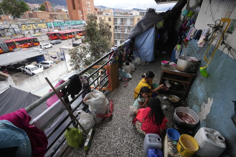 Indígenas embera desplazados por años de conflicto armado interno y condiciones de vida precarias en la región central occidental de Colombia preparan su almuerzo en un refugio después de viajar a Bogotá, el jueves 28 de noviembre de 2024. (AP Foto/Fernando Vergara)