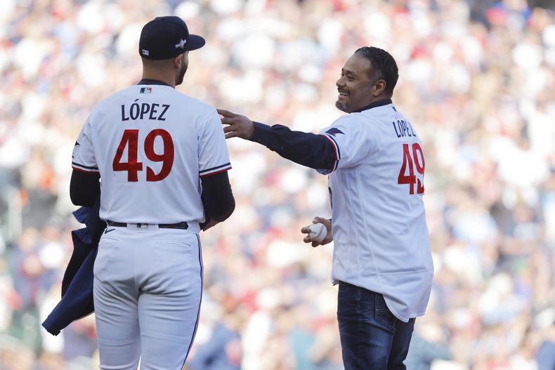 El exlanzador de los Mellizos de Minnesota, Johan Santana (derecha), habla con su compatriota venezolano Pablo López, antes de hacer el primer lanzamiento del tercer juego de la serie divisional de la Liga Americana, ante los Astros de Houston (AP Foto/Bruce Kluckhorn)