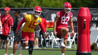 El mariscal de campo de los Chiefs de Kansas City, Patrick Mahomes (15), y el ala cerrada de los Chiefs de Kansas City, Travis Kelce (87), realizan ejercicios de estiramiento durante el entrenamiento del equipo de la NFL el martes 9 de junio de 2026 en Kansas City, Misuri. (Foto AP/Ed Zurga)