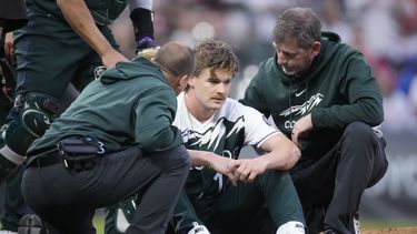 Los asistentes médicos atienden al lanzador abridor de los Rockies de Colorado, Ryan Feltner, después de haber sido golpeado por un batazo de Nick Castellanos, de los Filis de Filadelfia, quien bateó sencillo durante la segunda entrada del juego de béisbol el sábado 13 de mayo de 2023, en Denver. (AP Foto/David Zalubowski)
