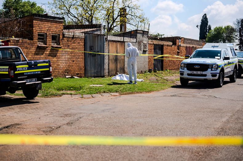 Un forense trabaja en la escena donde se encontró el cuerpo de una mujer en una carretera en KwaThema, Springs, Sudáfrica, el martes 15 de septiembre de 2026. (Foto de AP)
