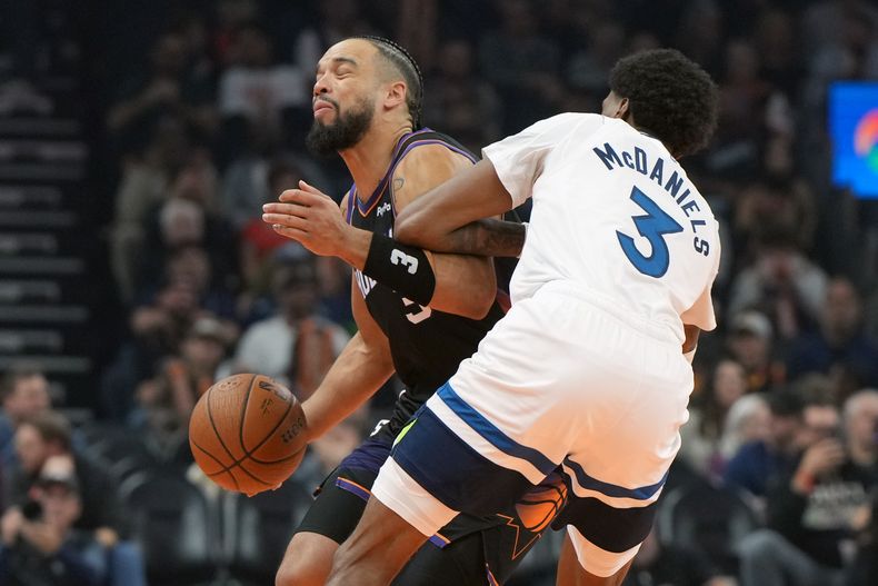 Dillon Brooks, de los Suns de Phoenix, trata de avanzar ante Jaden McDaniels, de los Timberwolves de Minnesota, el viernes 21 de noviembre de 2025 (AP Foto/Rick Scuteri)